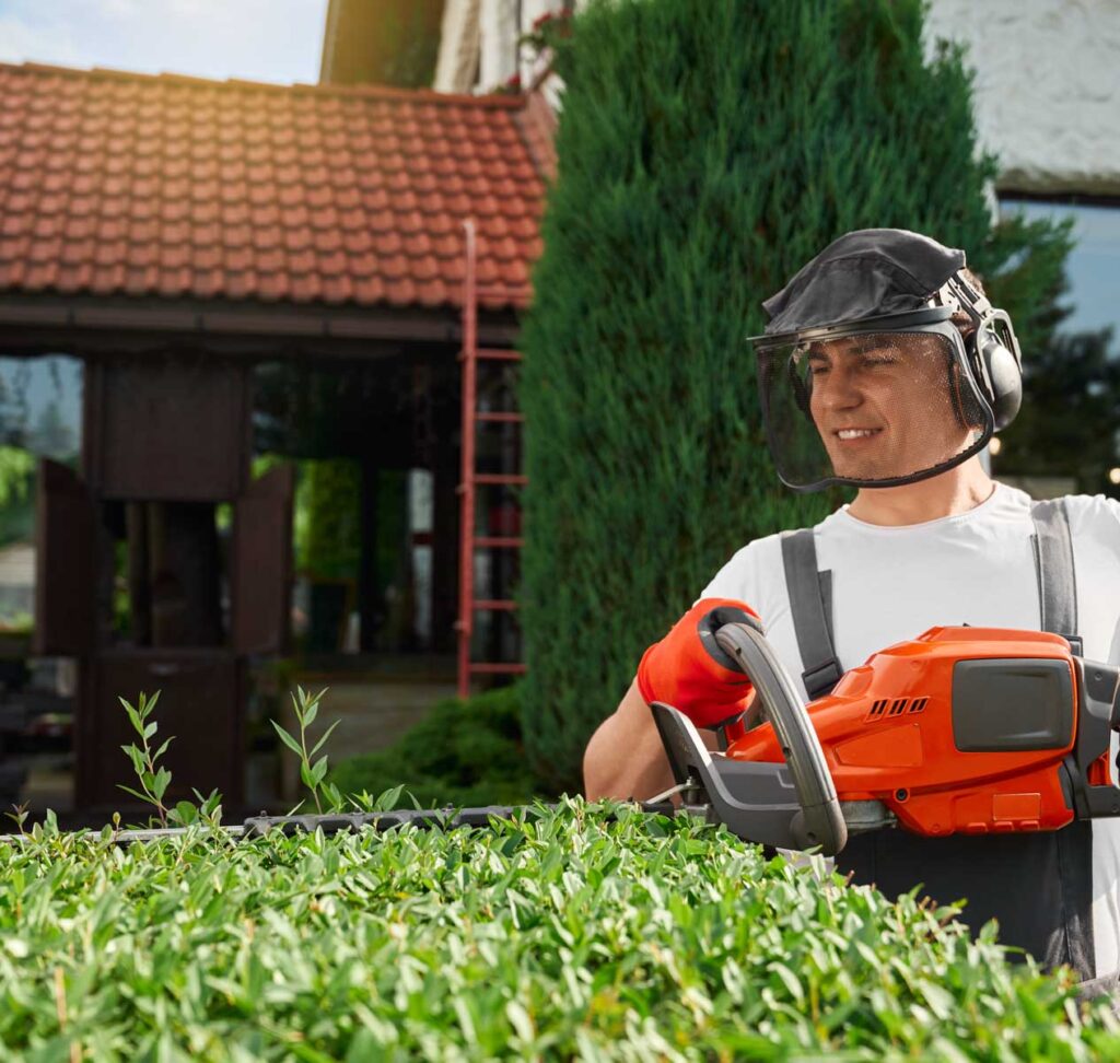 joven-con-mascara-de-seguridad-y-guantes-formando-arbustos